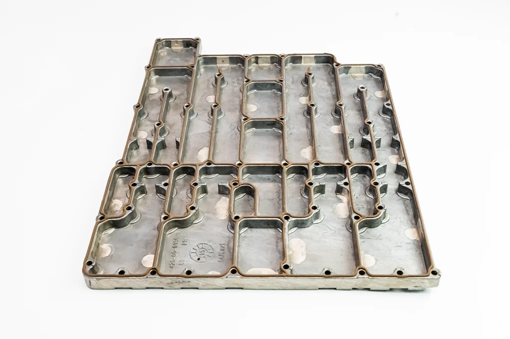 Diecast aluminum part with an EMI silver based gasket.