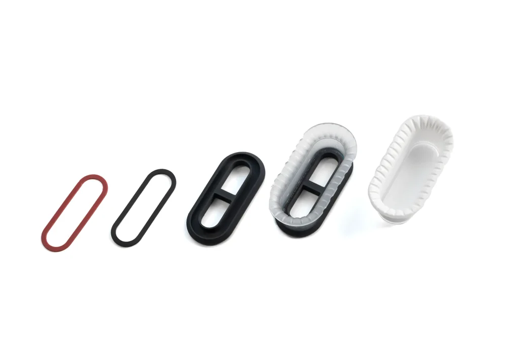 Cosmetic white lightpipes for a medical customer. From left to right: custom silicone ring, 3D printed clasp and mask, masked part, finished part.